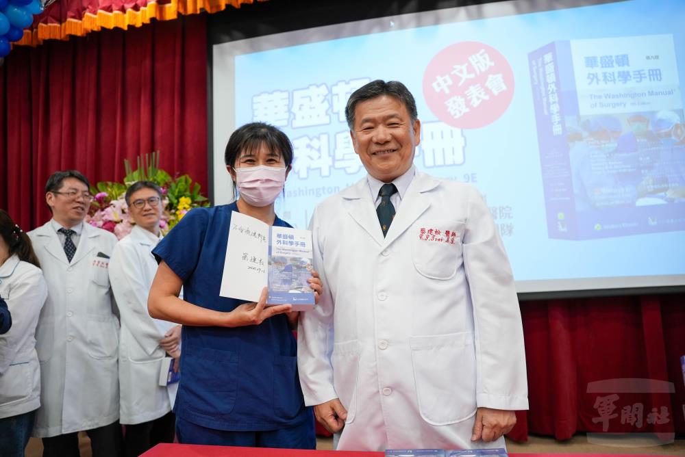 簽書活動中，蔡建松局長簽署譯本，與參與醫療人員互動熱絡，凝聚醫學傳承共識。（軍聞社記者莊家豪攝）