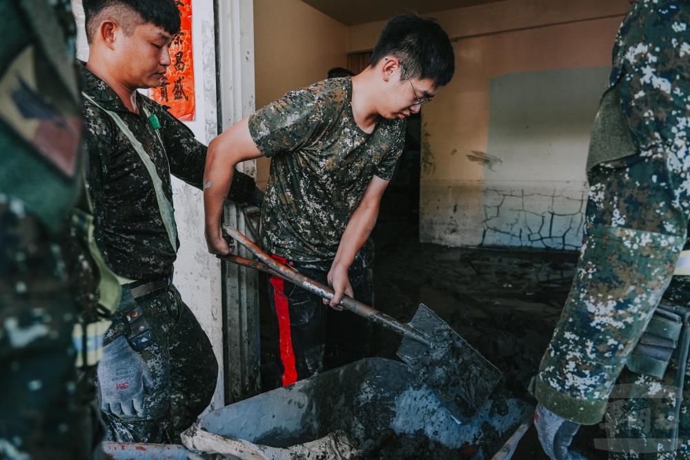 郭上士與前來支援的東指部官兵協力清除家中淤泥。（軍聞社記者陳傳奇攝）