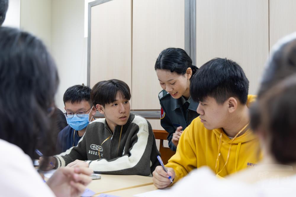 學員與管理學院學生討論辯論方式。（軍聞社記者吳柏融攝）