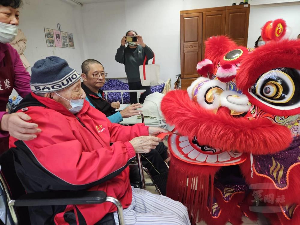 桃園榮家長輩們與祥獅互動，親手觸摸獅頭祈願平安順遂。（桃園榮家提供）