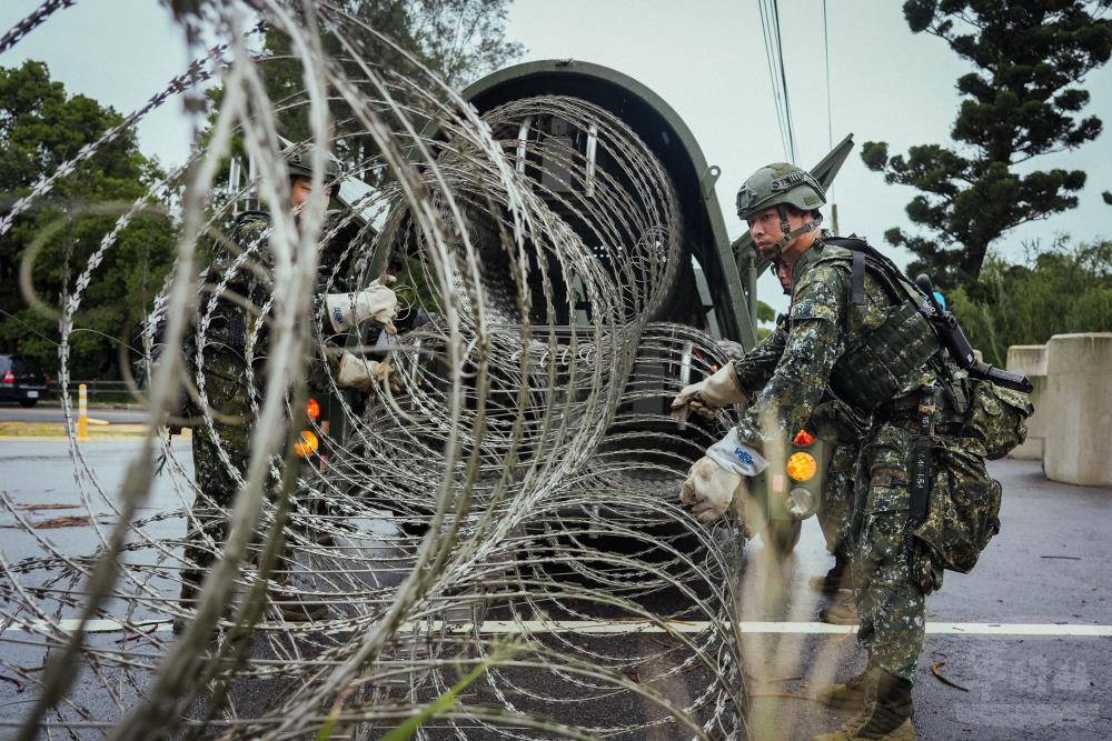 官兵架設蛇腹型鐵絲網。（軍聞社記者陳傳奇攝）