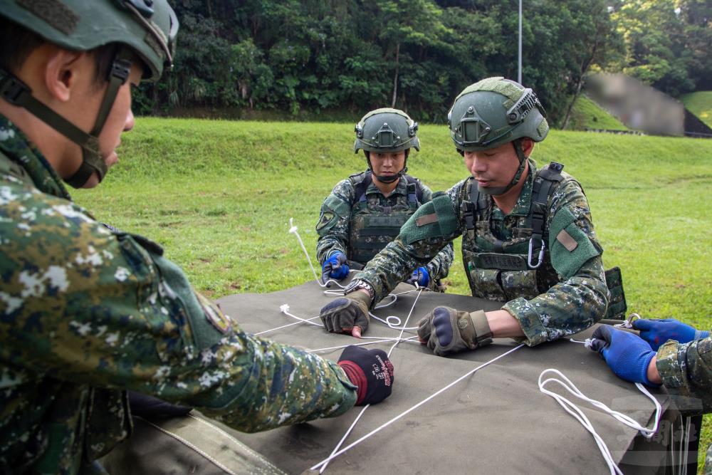 後勤部隊與陸航部隊官兵通力合作進行彈藥綑紮、包覆作業。（軍聞社記者王進福攝）