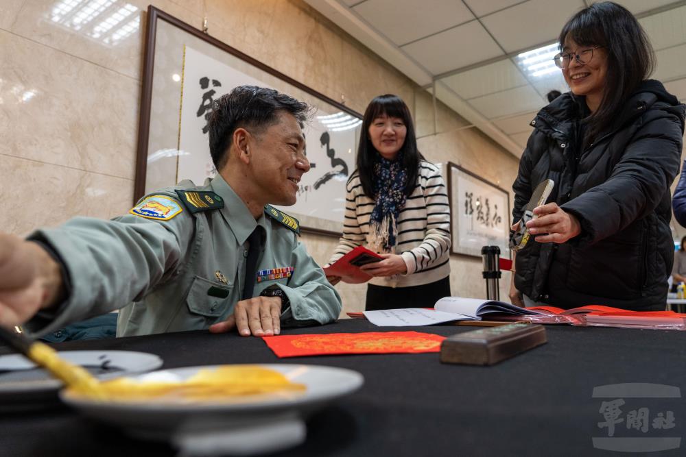 受邀揮毫的老師們為同仁客製化春聯。（軍聞社記者吳東昇攝）