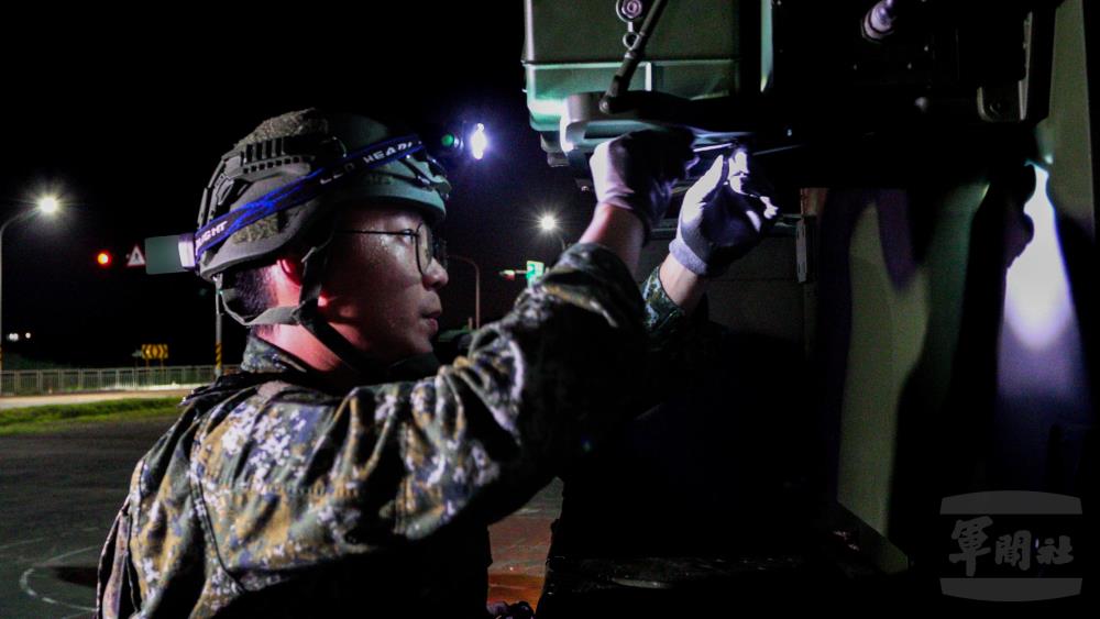 檢修官兵頂著夜色搶修飛彈車。（軍聞社記者王進福攝）