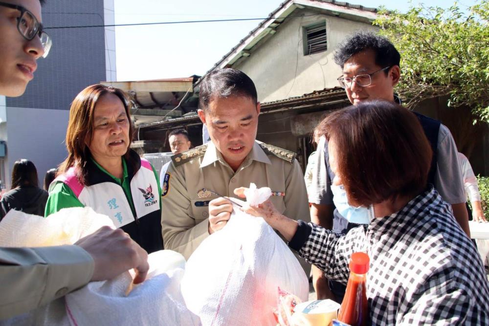 憲兵第203指揮部政戰主任謝上校（中）與社團法人川啟愛心重車協會理事覃安邦（左）發放物資。（社團法人川啟愛心重車協會提供）