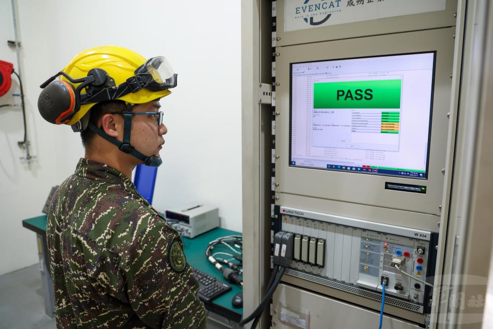 官兵在電工測試間操作線束測試臺，測試車輛電源線導通是否正常。（軍聞社記者蔡枋澐攝）