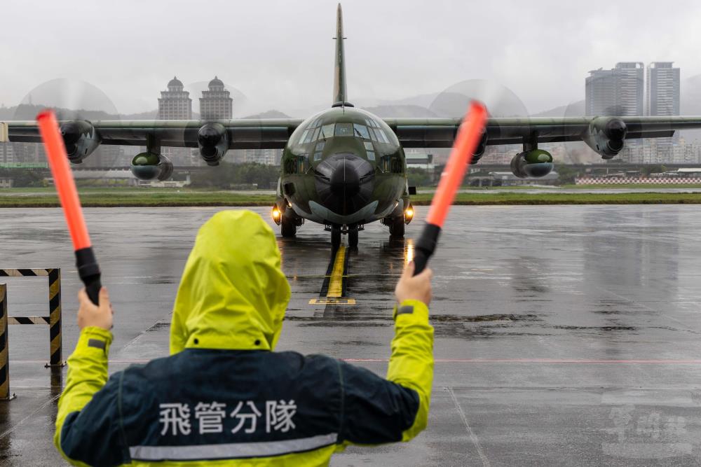 地勤官兵引導C-130運輸機進入停機坪。（軍聞社記者蔡枋澐攝）