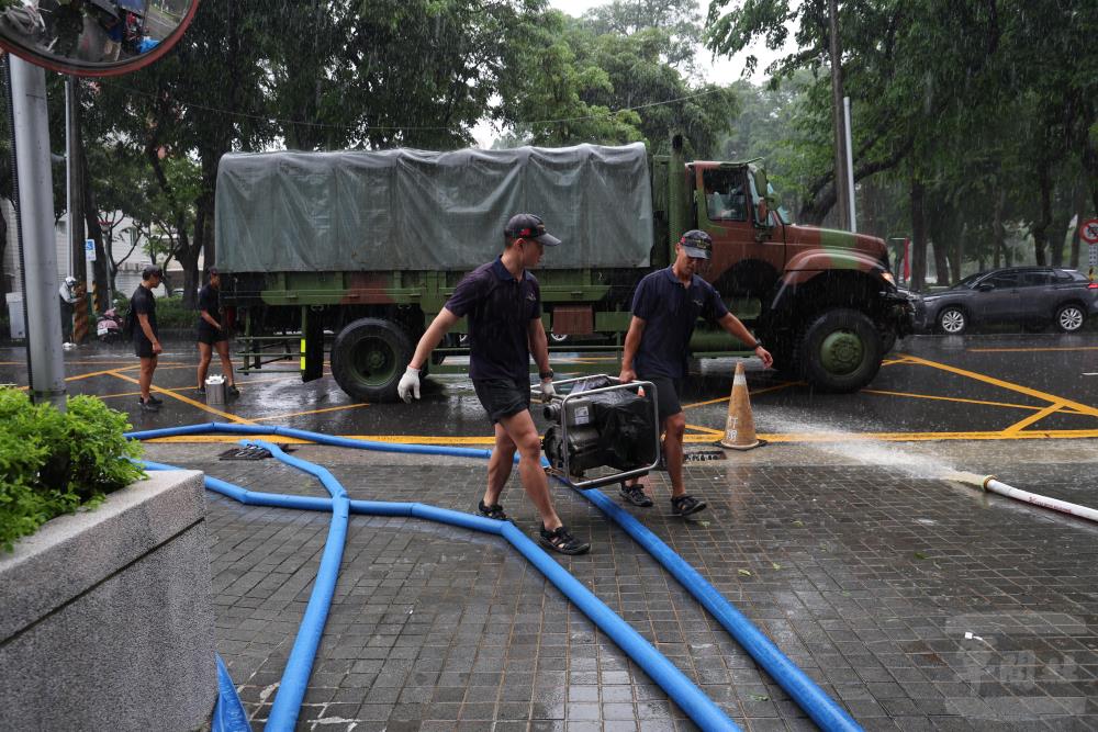 官兵雨中搬運機具。（軍聞社記者林澤廷攝）