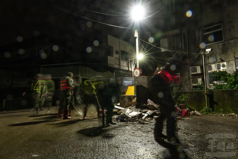 官兵以土工器具清除路面淤泥。（軍聞社記者吳東昇攝）