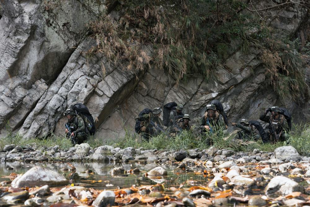 學員沿大甲溪河床向目標區實施滲透。（軍聞社記者李恬恬攝）