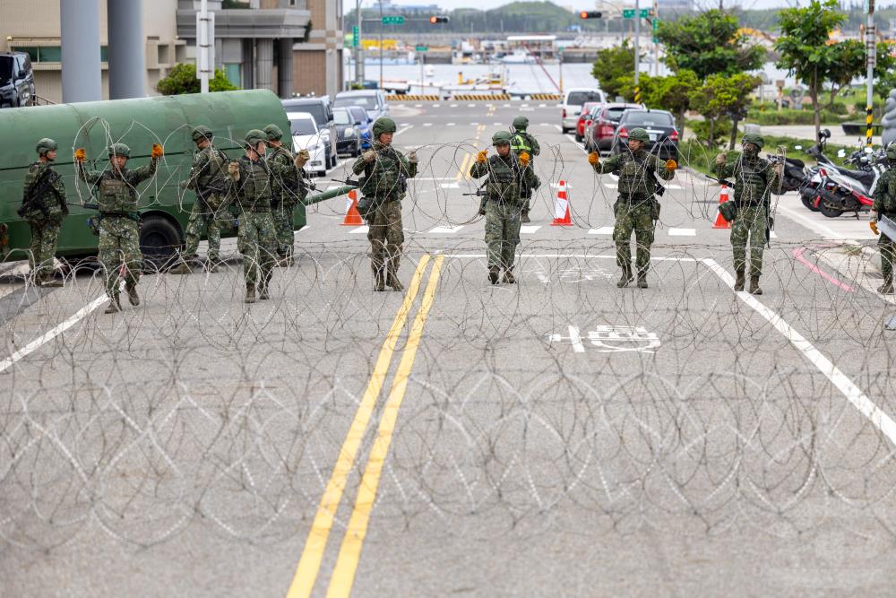 官兵於市區道路架設蛇腹型鐵絲網。（軍聞社記者蔡枋澐攝）