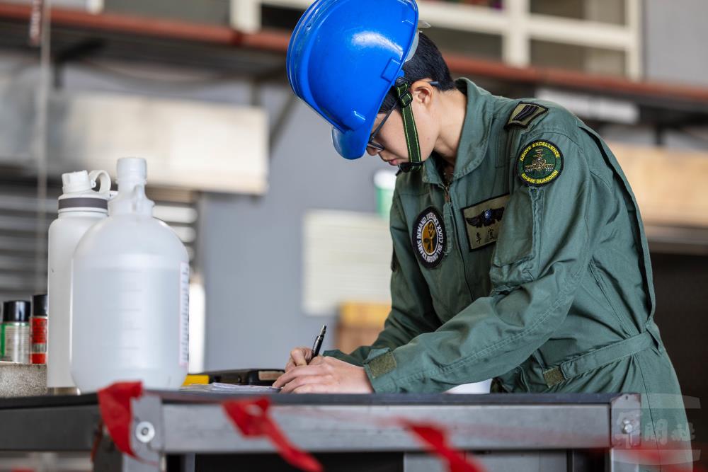 完成檢驗流程後，為阿帕契攻擊直升機簽名認證。（軍聞社記者蔡枋澐攝）