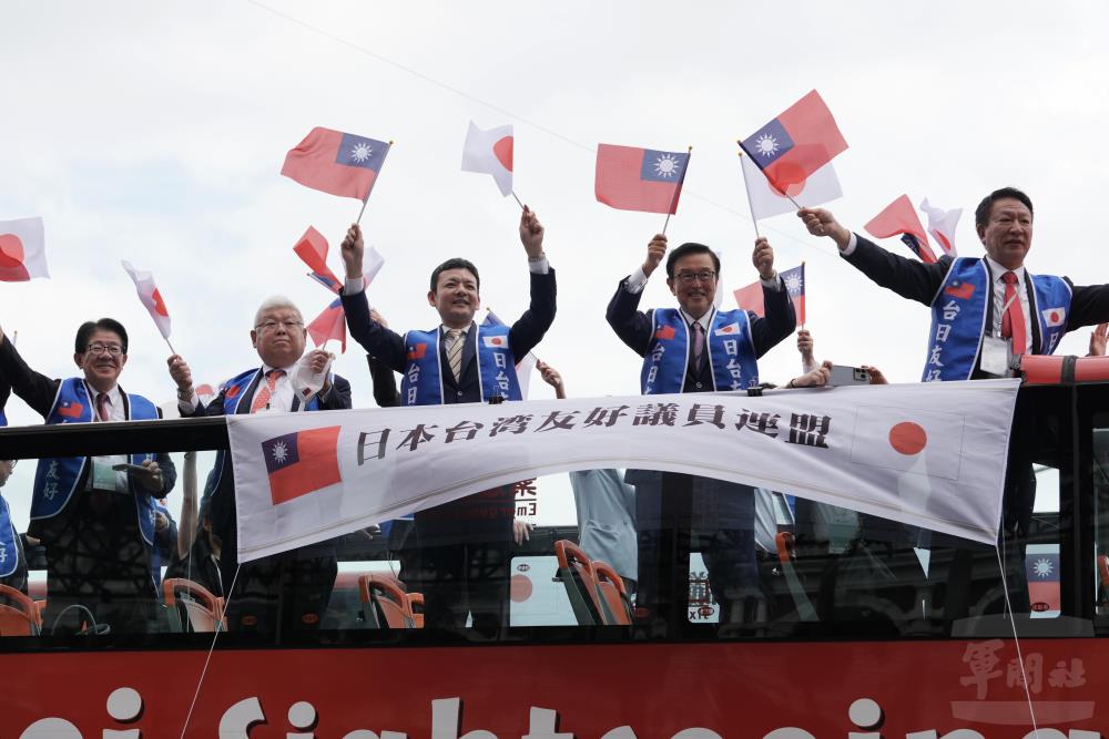 日本國會議員國慶祝賀團與立法院台日交流聯誼會共同組成遊行車隊，揮舞臺日兩國國旗向民眾致意。（軍聞社記者王茗生攝）