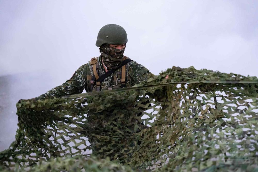 官兵於陣地鋪設偽裝網。（軍聞社記者林庭暉攝）