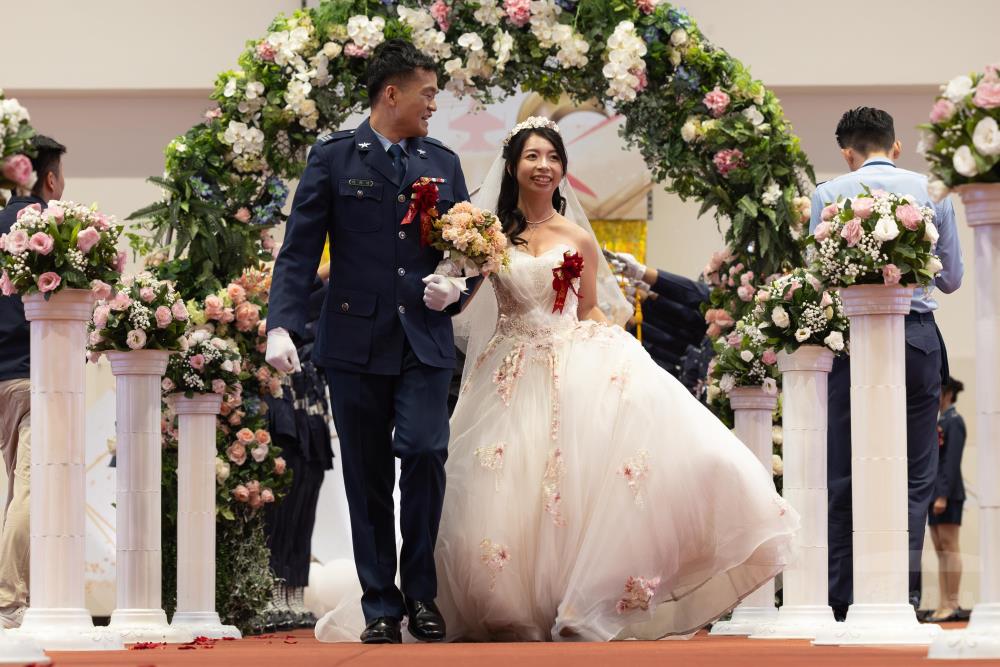 新人們穿越花型拱門。（軍聞社記者蔡枋澐攝）