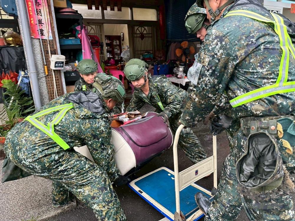 第四作戰區官兵與民眾協力清除活動中心淤泥，恢復家園環境。（第四作戰區提供）