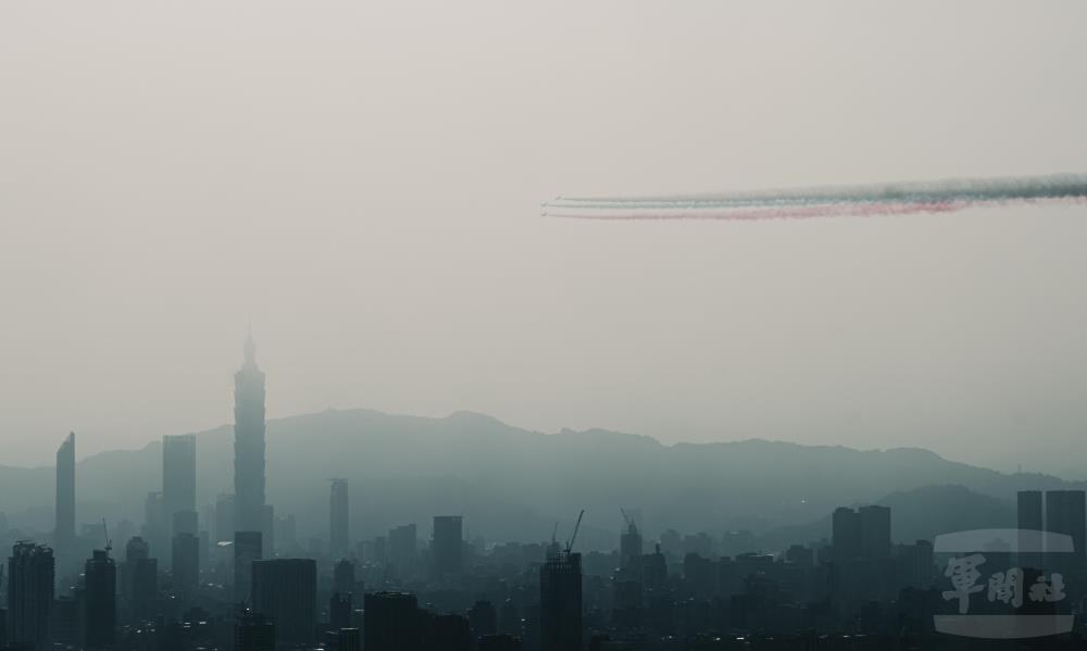 勇鷹高級教練機，自總統府後方，噴著紅藍彩煙衝場。（軍聞社記者陳軍均攝）